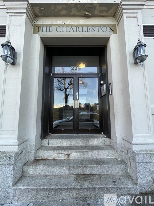 The Charleston building entrance with a glass door and steps.