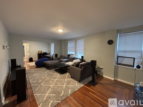 A living room with a grey couch and a rug.
