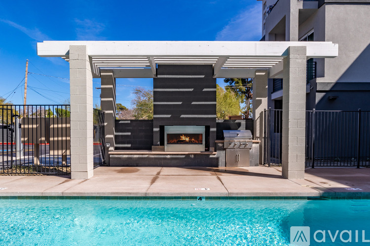 A modern outdoor living space with a pool and a fireplace.