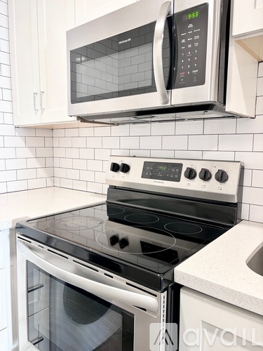 A modern kitchen with a stove top oven and microwave above it.