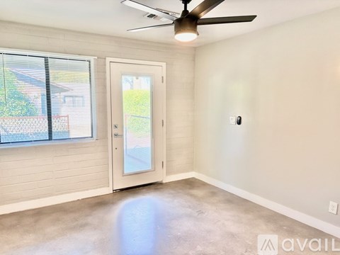 A room with a ceiling fan and a door leading outside.