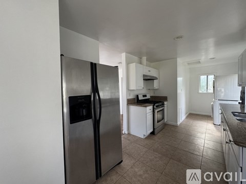 A kitchen with a stainless steel refrigerator and a sink.