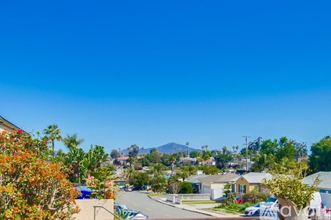 A sunny day in a residential neighborhood with houses and trees.