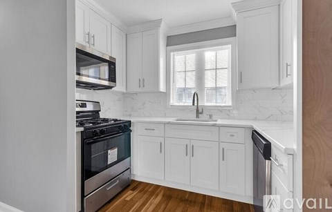 A kitchen with white cabinets and a black stove top oven.