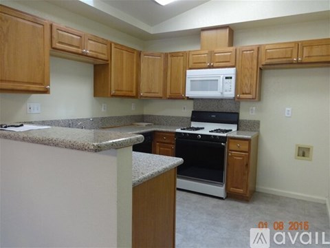 A kitchen with wooden cabinets and a granite countertop.