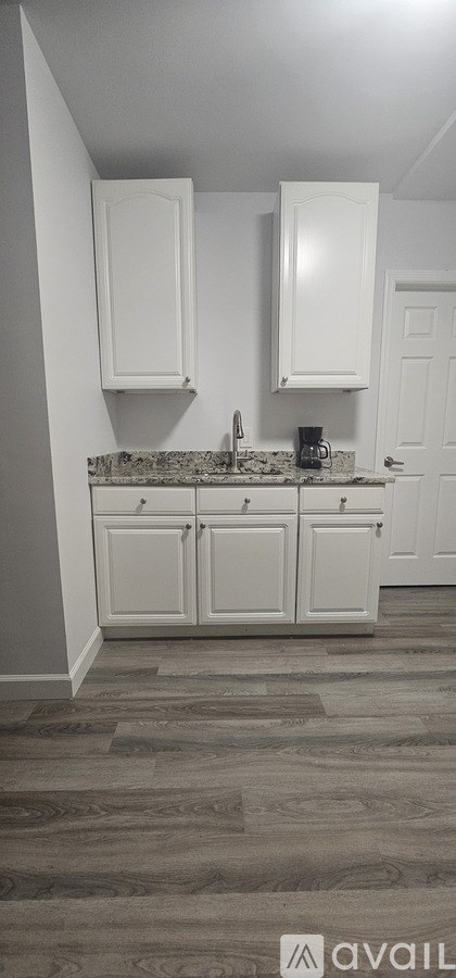 A kitchen with white cabinets and a countertop.