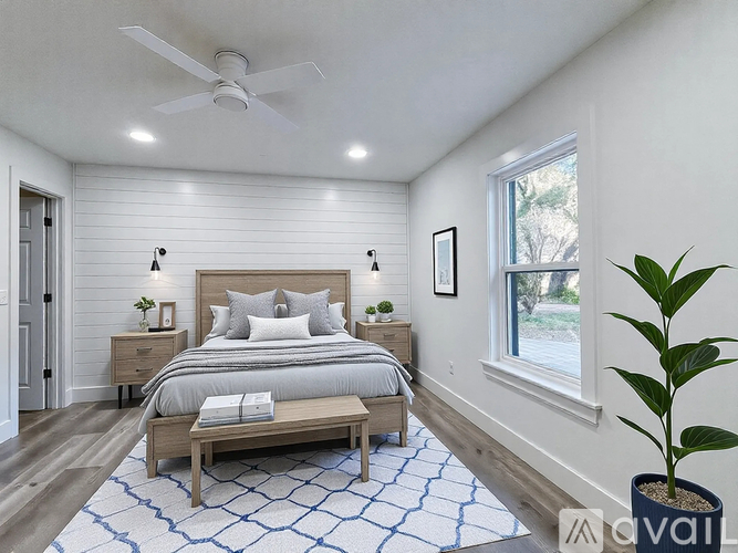 A bedroom with a bed, nightstands, and a ceiling fan.