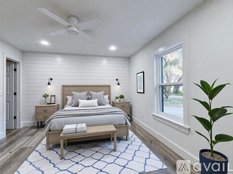 A bedroom with a bed, nightstands, and a ceiling fan.
