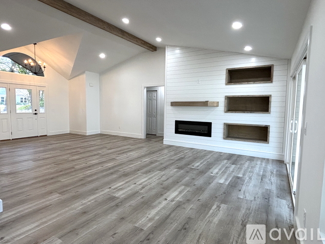 A spacious living room with a fireplace and wooden flooring.