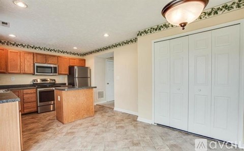 A kitchen with wooden cabinets and a tiled backsplash.