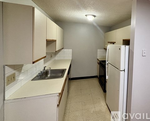 A kitchen with white appliances and cabinets.