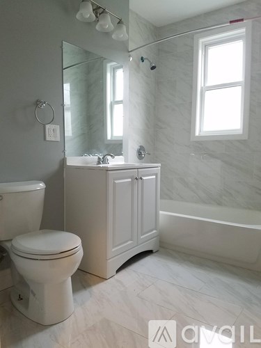 A white bathroom with a toilet, sink, and bathtub.
