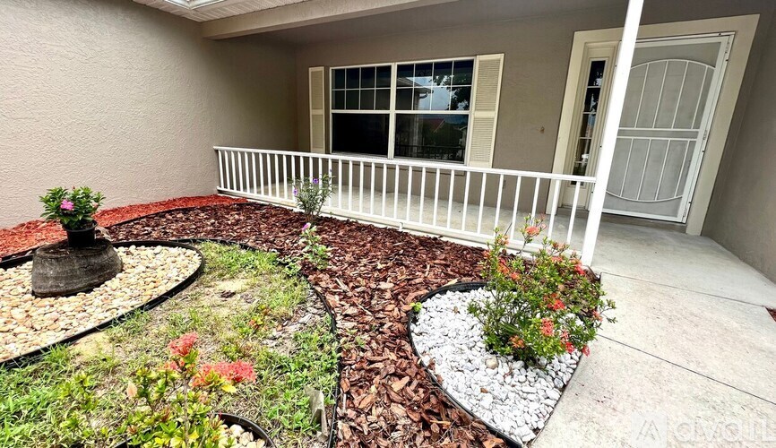 A small garden with a white railing and a small fountain.