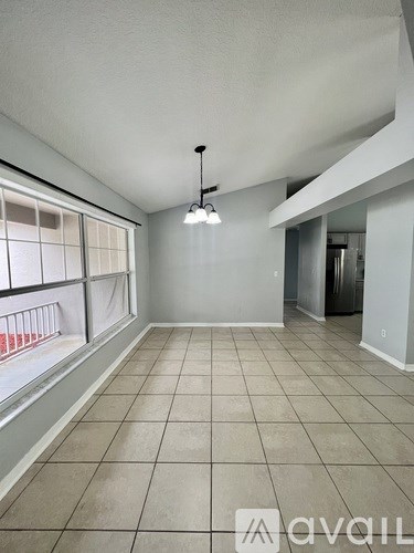 A room with tiled flooring and a window with blinds.