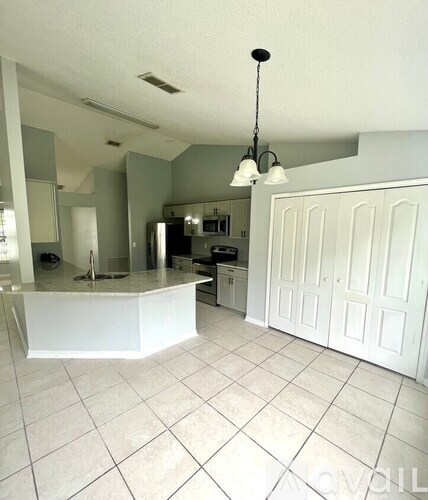 A kitchen with white cabinets and a white island.