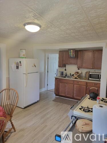 A kitchen with a white fridge and wooden cabinets.
