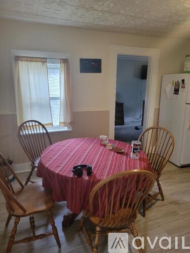 A dining room with a round table and chairs.