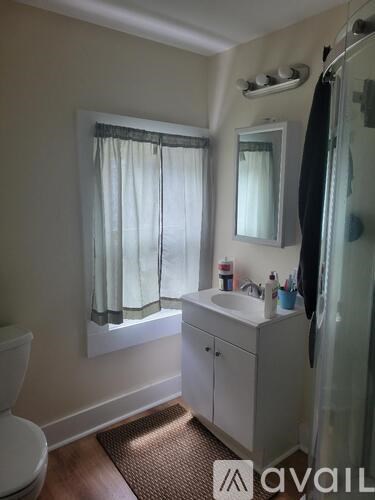 A bathroom with a toilet, sink, and shower.