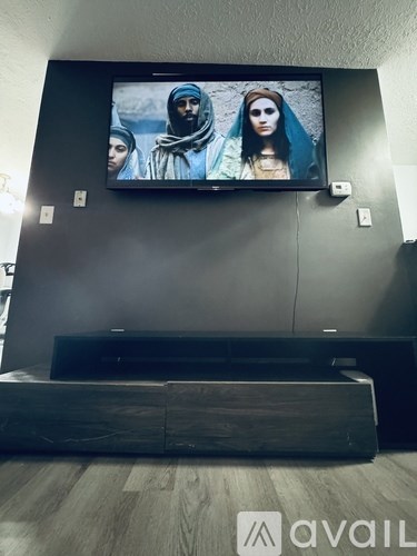 A television screen shows three people, two men and a woman.