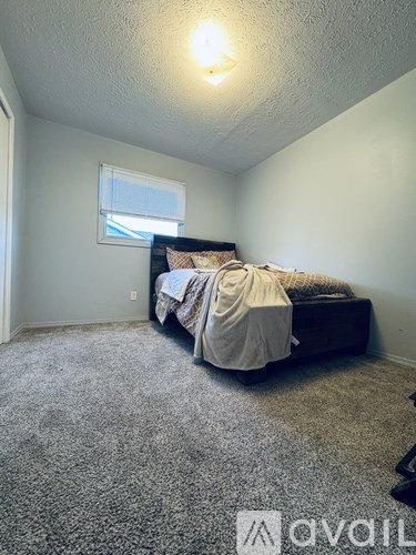 A bedroom with a bed and a window.