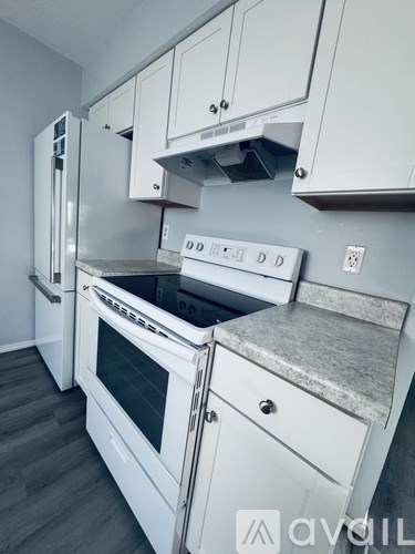 A kitchen with white appliances and cabinets.