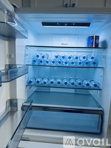 A refrigerator with a glass shelf and a water dispenser.