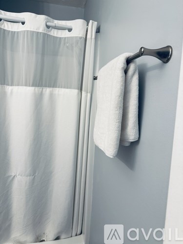 A white towel is hanging on a silver towel rack.