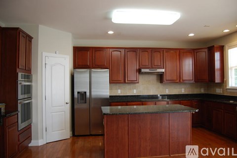 A kitchen with wooden cabinets and a black countertop.