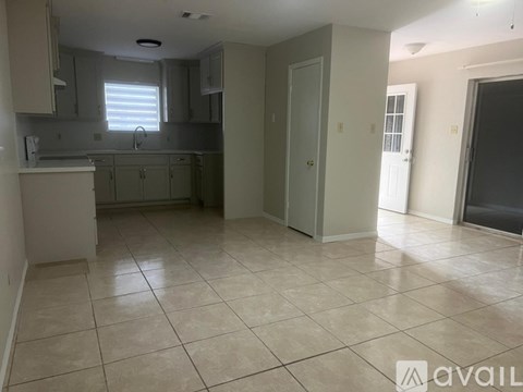 A kitchen with white cabinets and a tiled floor.