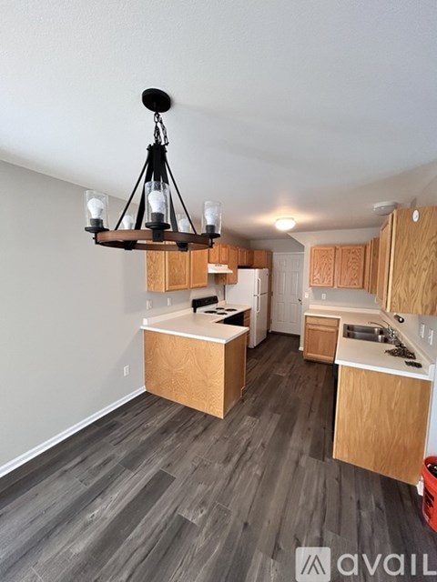A kitchen with wooden cabinets and a chandelier.