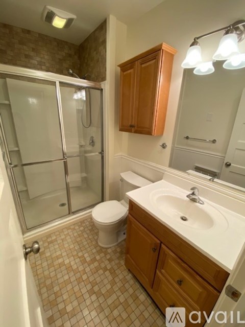 A bathroom with a toilet, sink, and shower.