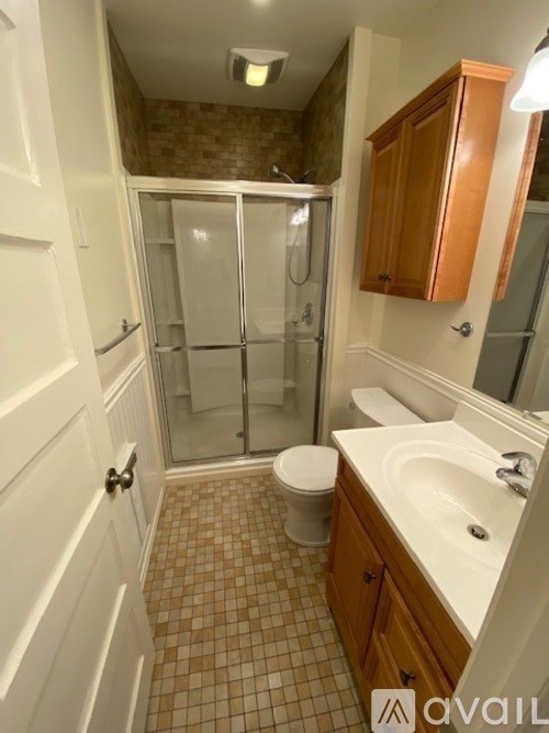 A bathroom with a toilet, sink, and shower.