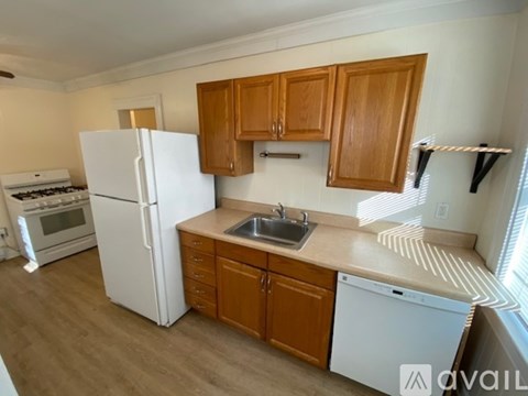 A kitchen with wooden cabinets and a white refrigerator.