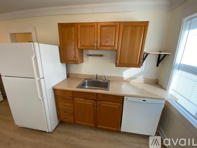 A kitchen with wooden cabinets and a white fridge.