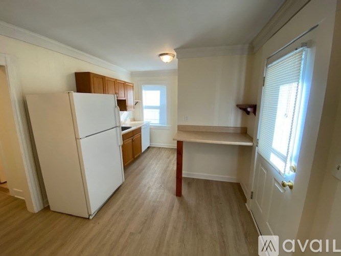 A kitchen with a white fridge and wooden cabinets.