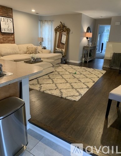 A modern living room with a white sofa and a wooden floor.
