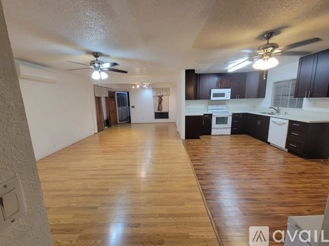 A kitchen with a refrigerator, microwave, and oven is visible.