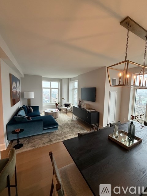 A living room with a blue couch and a wooden table.