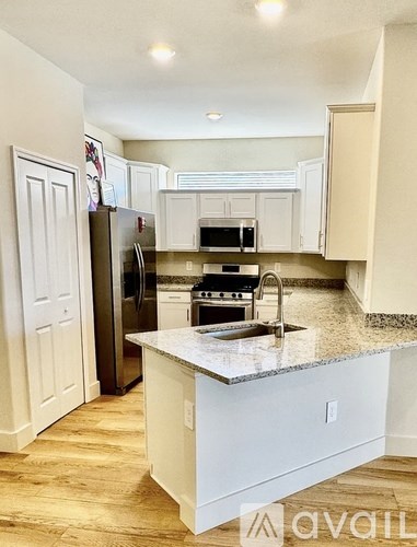 A kitchen with a white island and a refrigerator.