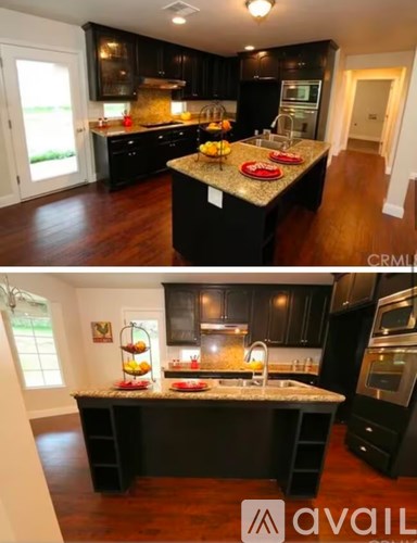 A kitchen with black cabinets and a granite countertop.