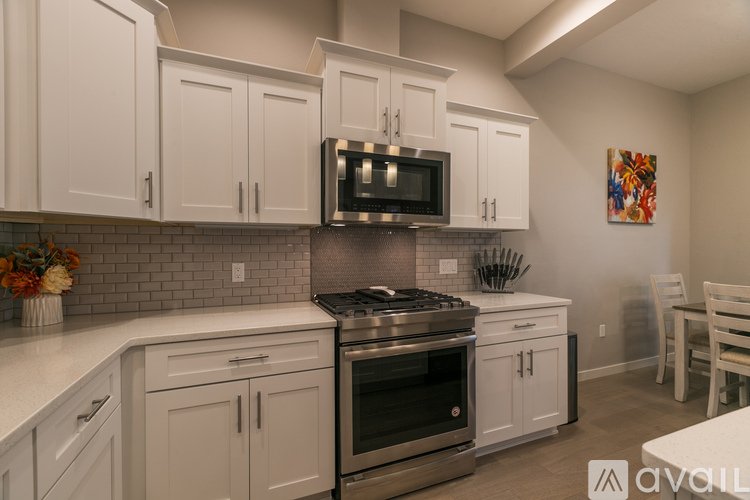 A kitchen with white cabinets and a black stove top oven.