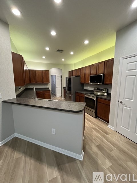 A kitchen with wooden cabinets and a white island.