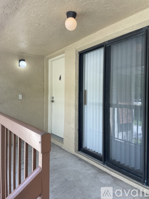 A balcony with a sliding door and a chair.