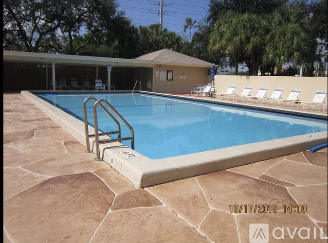 A pool with a stone floor and a metal ladder.