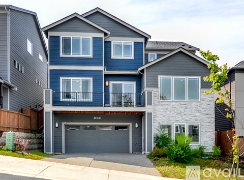 A two-story house with a garage and a balcony.