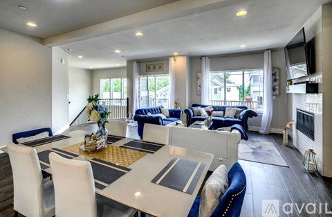 A modern living room with a dining table and blue chairs.