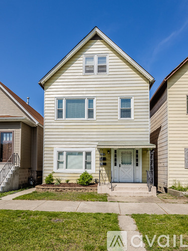 A two-story house with a front porch and a white door.