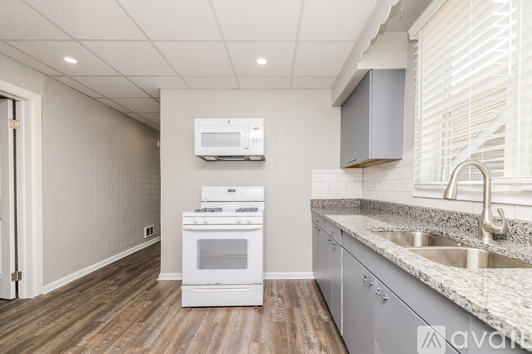 A kitchen with a white oven and microwave.