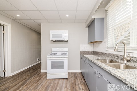 A kitchen with a white oven and microwave.