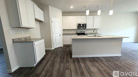 A kitchen with white cabinets and a granite countertop is available for rent.